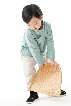 可爱的小男孩拿着簸箕