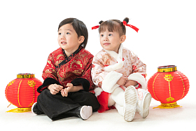 庆祝新年的两个小朋友坐在地上玩耍