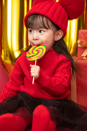 过新年的小女孩吃棒棒糖图片