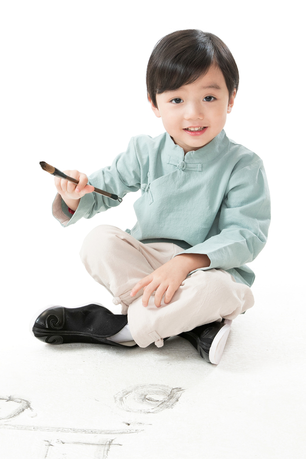 可爱的小男孩坐在地上用毛笔写字 可爱的小男孩坐在地上用毛笔写字