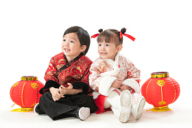 庆祝新年的两个小朋友坐在地上玩耍