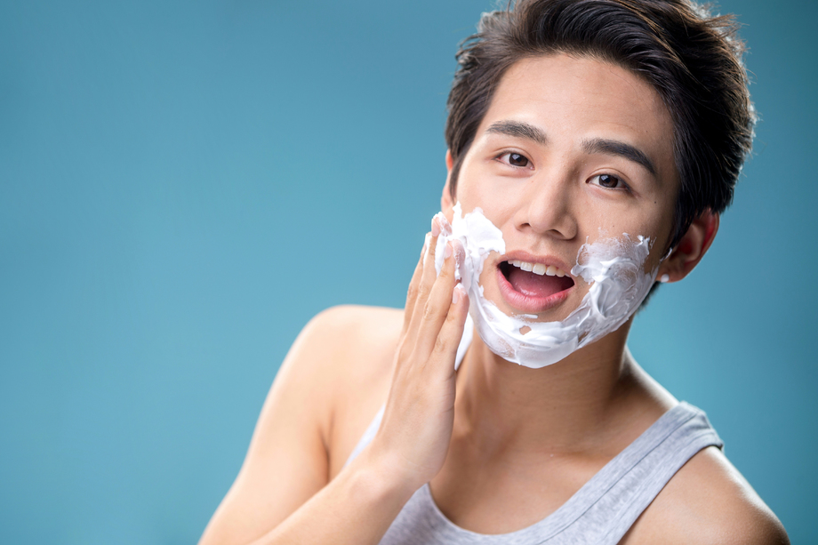 年轻男人涂抹剃须膏图片