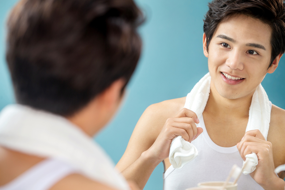 年轻男人拿着毛巾照镜子图片