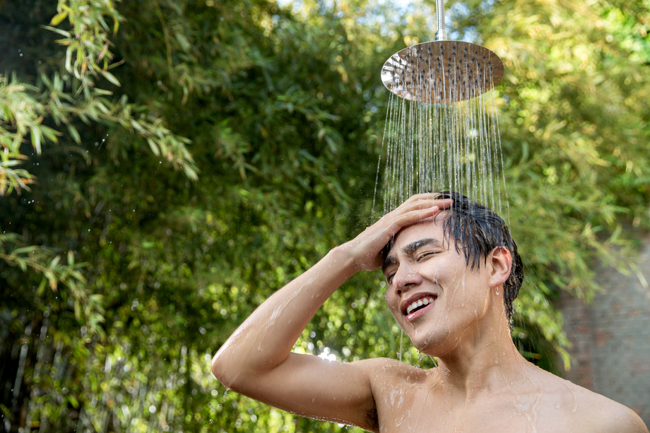 年轻男人在户外淋浴洗头照片