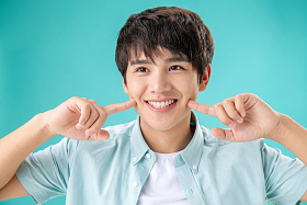 用手指着脸笑的年轻男人图片