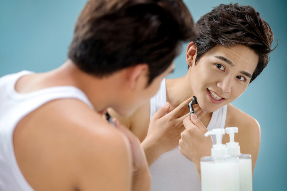青年男人对着镜子刮胡子图片