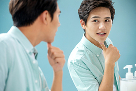 年轻男人对着镜子做手势