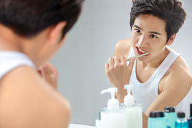 年轻男人对着镜子在刷牙