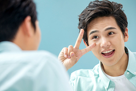 自信的年轻男人对着镜子做手势