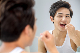 年轻男人对着镜子在刷牙图片