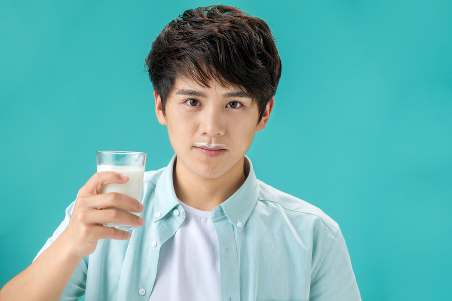 年轻男人喝牛奶照片