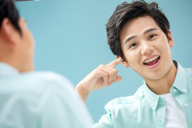 自信的年轻男人对着镜子做手势