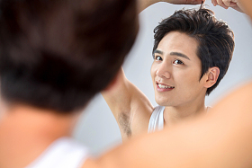 照着镜子做发型的年轻男人图片