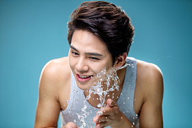 年轻的男人捧水洗脸