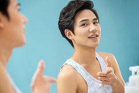 自信的年轻男人对着镜子做手势