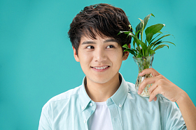 拿着绿色植物的青年男人