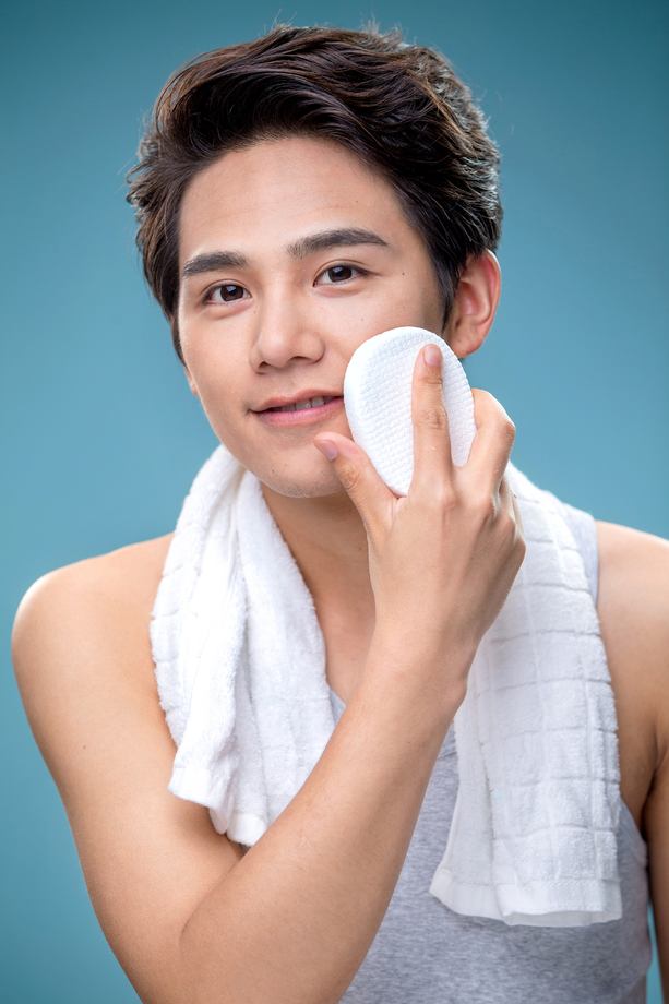 用面扑擦脸的年轻男人图片