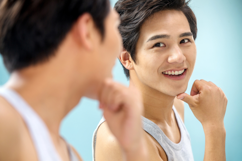 快乐的年轻男人对着镜子做手势 快乐的年轻男人对着镜子做手势