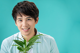 拿着绿色植物的青年男人图片