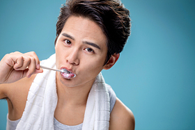 年轻男人在刷牙照片