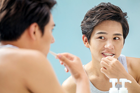 年轻男人对着镜子在刷牙