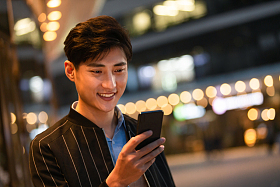 商务男士走在路上看手机照片