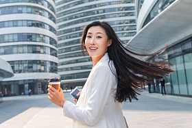 拿着咖啡杯的快乐商务女士照片