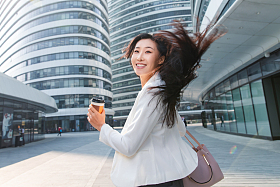 拿着咖啡杯的快乐商务女士