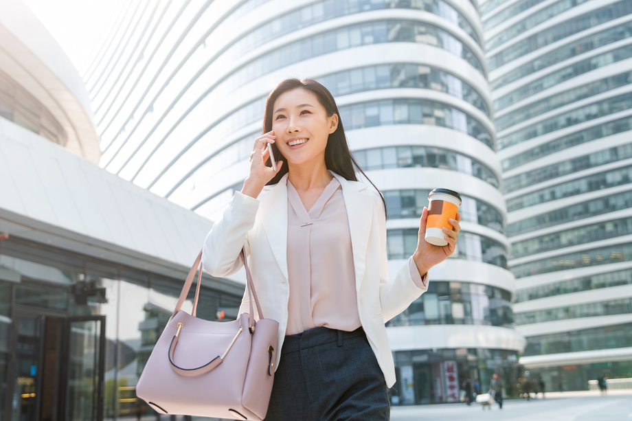 拿着咖啡的商务女性打电话