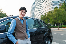 站在汽车旁的商务青年照片