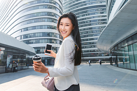 拿着咖啡杯的快乐商务女士