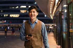 商务男士走在路上看手机图片