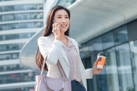 拿着咖啡的商务女性打电话