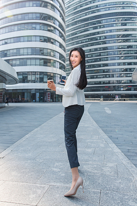 拿着咖啡杯的快乐商务女士图片