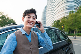 站在汽车旁的商务青年照片