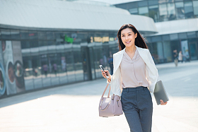 在外面步行的青年商务女人