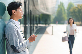 站在户外的商务男士看手机