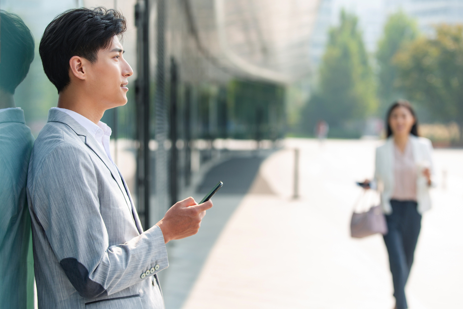 站在户外的商务男士看手机