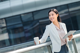 拿着平板电站在户外的商务女士