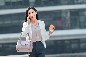 拿着咖啡的商务女性打电话