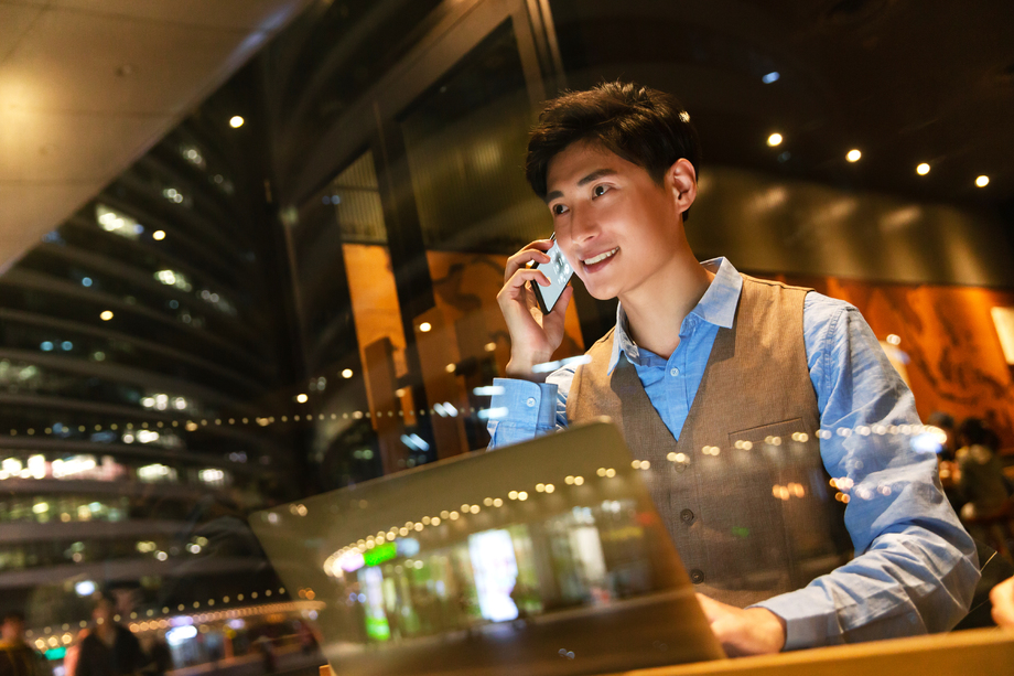 商务男士边用电脑边打电话图片 商务男士边用电脑边打电话图片