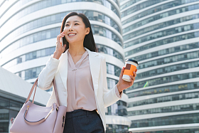 拿着咖啡的商务女性打电话