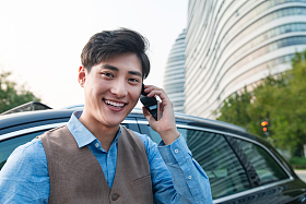 站在汽车旁打电话的商务男士