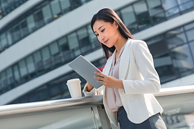 拿着平板电站在户外的商务女士