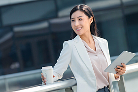拿着平板电站在户外的商务女士