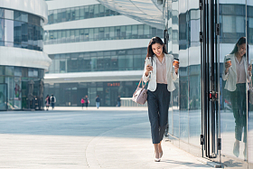 拿着咖啡的商务女性看手机图片