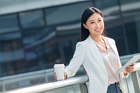 拿着平板电站在户外的商务女士