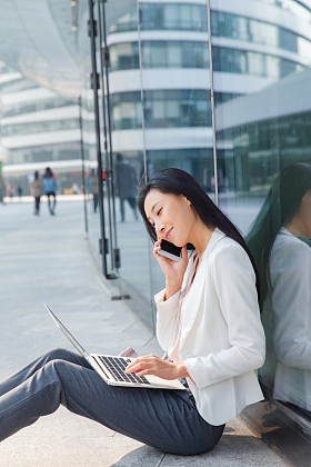 商务女性坐在地上打电话