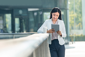 拿着平板电站在户外的商务女士