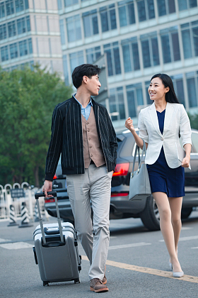 青年伴侣拉着行李箱旅